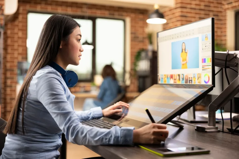 Designer drawing with a stylus on a pen display in a studio